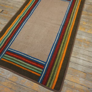 Textured beige runner rug framed by olive green and multi-colored stripes rests on weathered wood planks.