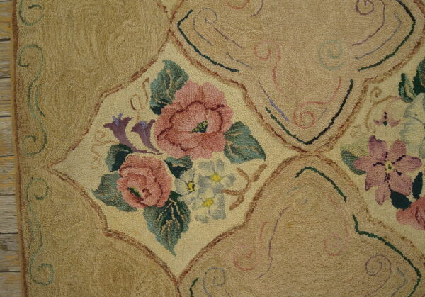 Textured beige rug with repeating panels containing pink and green floral bouquets and swirling accents.