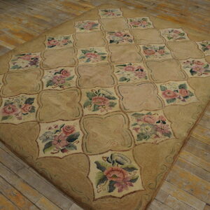 A tan plush rug with a floral quatrefoil grid pattern lies on distressed wooden floorboards.
