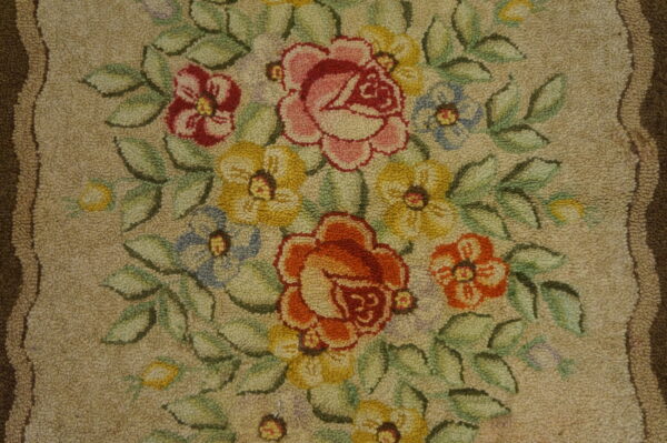 Looped pile rug displaying a vibrant floral bouquet with pink, orange, yellow, blue, and green colors on beige.