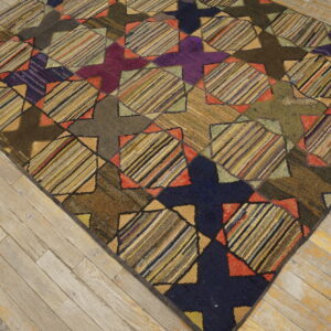 Textured rug featuring dark purple, navy, brown, and multicolored striped geometric patches on worn wood.