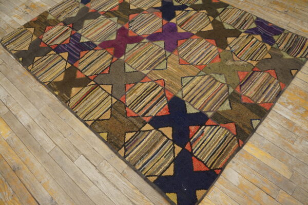 Textured rug featuring dark purple, navy, brown, and multicolored striped geometric patches on worn wood.