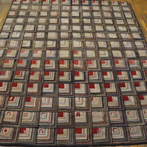 Geometric rug with a repeating pattern of multicolored concentric squares and red accents on wood flooring.