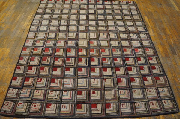 Geometric rug with a repeating pattern of multicolored concentric squares and red accents on wood flooring.