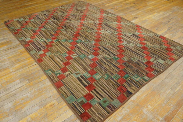 Earth-toned striped rug featuring a colorful red and teal block grid laid over worn hardwood floor.