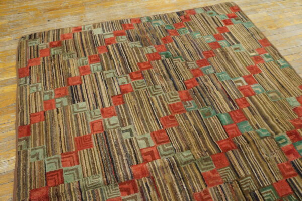 Highly textured rug with vertical striped earth tones and repeating red and teal geometric blocks on wood planks.