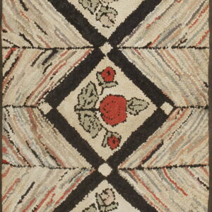 Hooked texture rug showing stacked black diamonds containing red and pink floral designs.