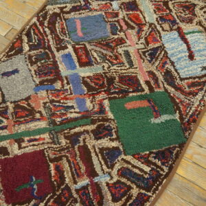 Abstract shaggy rug in bold jewel tones and brown, displayed on light rustic wood planks.