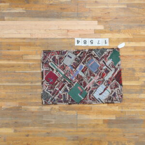 Shaggy, multicolored abstract rug with geometric shapes displayed on a light brown wood plank floor.