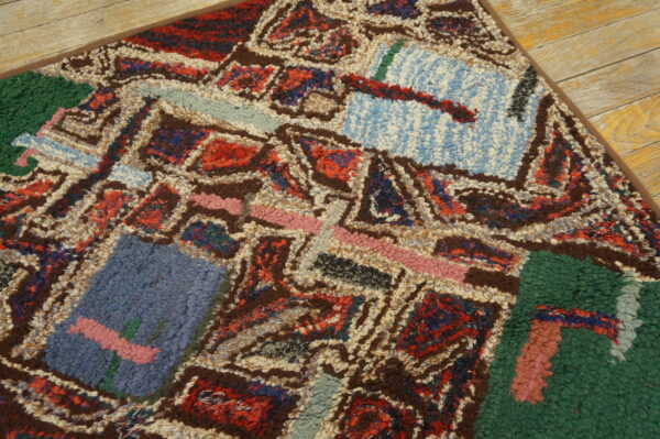 Shaggy, high-pile rug featuring multicolored abstract shapes rests on distressed wood flooring.