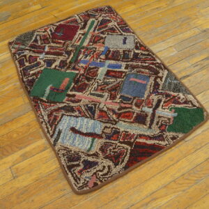 Geometric abstract rug featuring red, green, and blue blocks on worn light wood flooring.