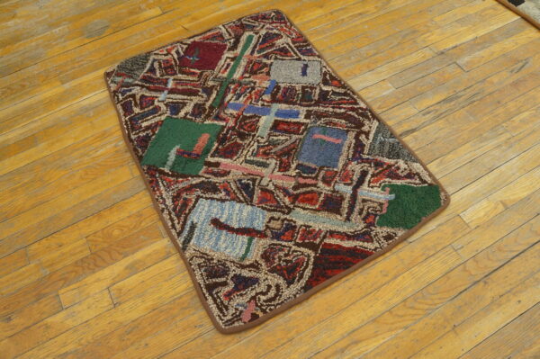 Geometric abstract rug featuring red, green, and blue blocks on worn light wood flooring.