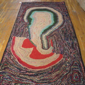 Multicolored rug with a dense texture and abstract striated pattern resembling an agate cross-section on wood planks.