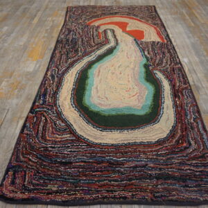 Abstract multicolored textured runner with a concentric design laid on distressed wood floorboards.