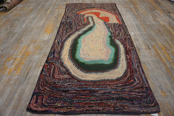 Abstract multicolored textured runner with a concentric design laid on distressed wood floorboards.