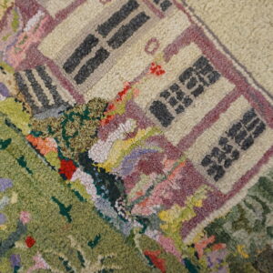 Textured rug with a detailed multicolored pictorial design showing a beige house and green landscape.