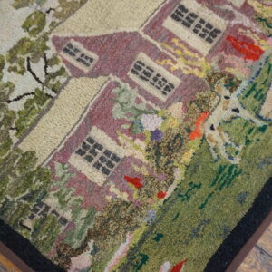 Multi-colored, hooked-style rug displaying a pictorial pattern of a burgundy house and lush green yard.