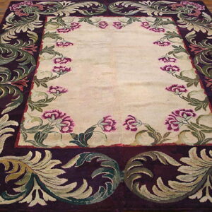 Cream rug featuring a wide, high-pile purple border with ornate sage green scrollwork and pink flowers.