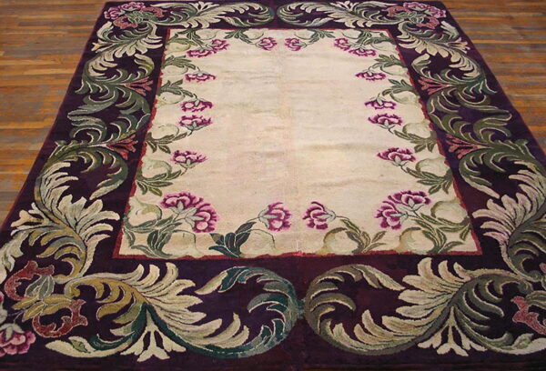 Cream rug featuring a wide, high-pile purple border with ornate sage green scrollwork and pink flowers.