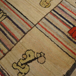 Looped rug features geometric blocks of colorful stripes alternating with beige blocks containing floral motifs.