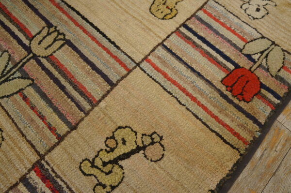 Looped rug features geometric blocks of colorful stripes alternating with beige blocks containing floral motifs.