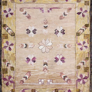 High-texture beige rug featuring stylized purple flowers and chevrons within a distressed yellow border.