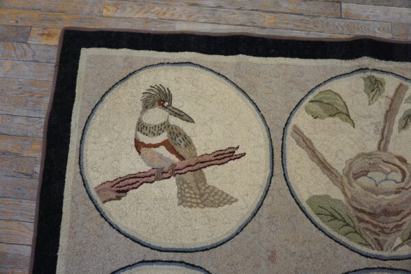Looped beige and taupe rug featuring bird and nest medallions rests on distressed wood plank flooring.
