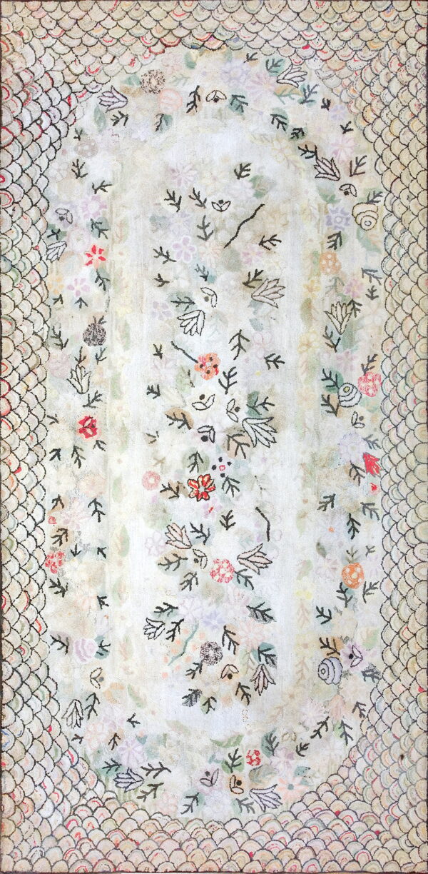 A cream rug with scattered light floral motifs bordered by a distinct black scallop scale pattern.