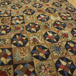 Earthy-toned rug with alternating botanical and geometric star patterns on light brown wooden floors.