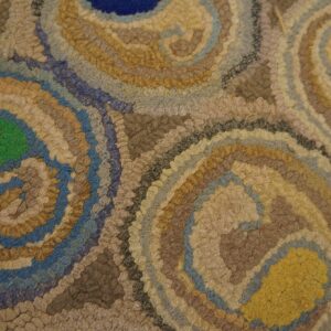 Textured rug close-up featuring large swirls of blue, green, red, yellow, and various neutral tones.