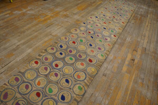 Tan runner rug featuring repeating circles with colorful centers on a distressed wood floor.