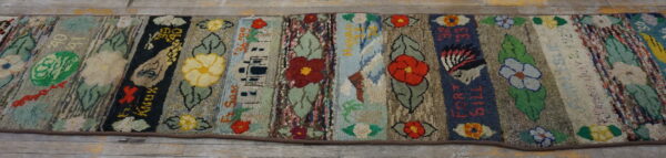 High-texture multi-colored runner featuring vertical patchwork panels of flowers, leaves, and written text on a wood floor.