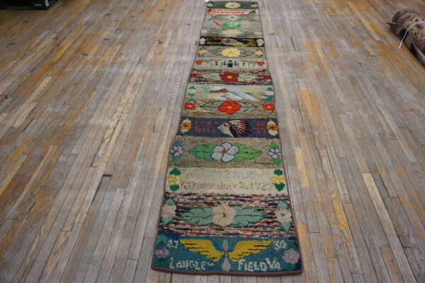Highly textured, multicolored runner rug featuring pictorial scenes and visible text lays on a distressed wood floor.