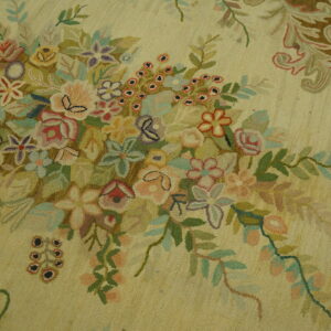 Pale yellow textured rug with a dense cluster of pink, green, blue, and purple flowers.