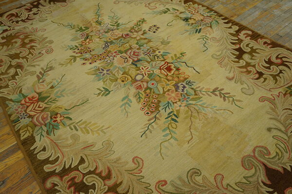 Beige rug featuring a large central bouquet of pastel flowers and a dark brown scrolling acanthus border on wood floor.
