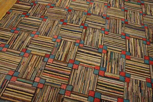 Textured diagonal grid rug with alternating horizontal and vertical multicolor stripes, punctuated by small red and teal blocks.