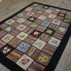 Patchwork rug with alternating squares of multicolored stripes and floral designs on a worn wood floor.