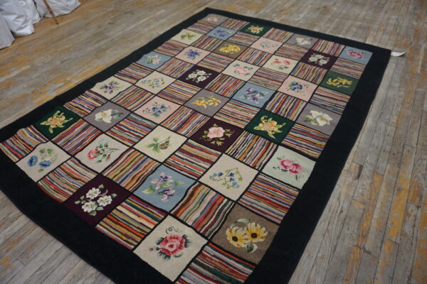 Patchwork rug with alternating squares of multicolored stripes and floral designs on a worn wood floor.