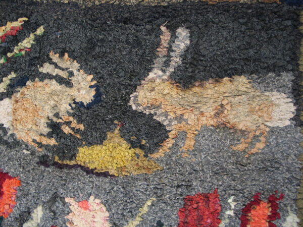 Highly textured, chunky looped rug with an abstract pattern in dark gray, tan, yellow, and red.