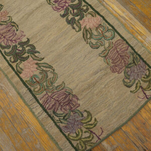 Low-pile beige runner rug with purple and pink floral borders on distressed wooden flooring.