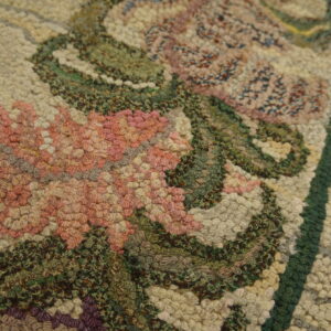 Set on a distressed wooden floor, a low-pile beige runner rug showcases gentle purple and pink floral borders.