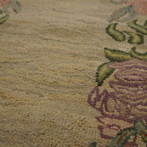 Low-pile beige runner rug featuring soft purple and pink floral border accents, styled on a distressed wood floor.