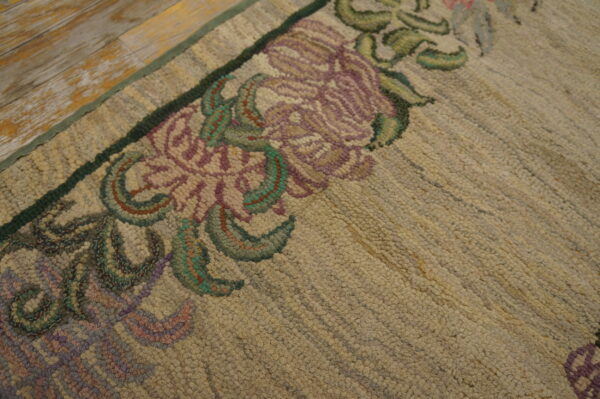 Low-pile beige runner rug with delicate purple and pink floral borders, photographed on a distressed wooden floor.