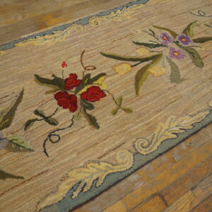 Textured beige runner with a floral pattern of red, purple, and yellow on old hardwood flooring.