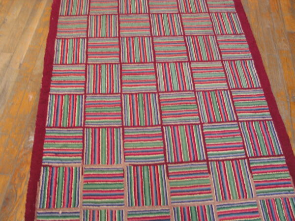 Multi-colored striped blocks in red, green, and blue form a checkerboard pattern on light wood flooring.