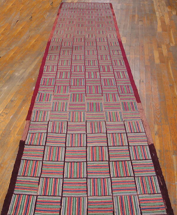 Multicolor checkerboard runner with red, green, and blue stripes on light plank wood flooring.
