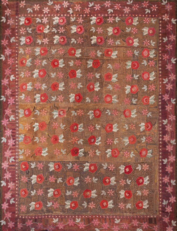 Textured brown and rust rug featuring red and pink floral motifs with grey leaves and elaborate decorative borders.