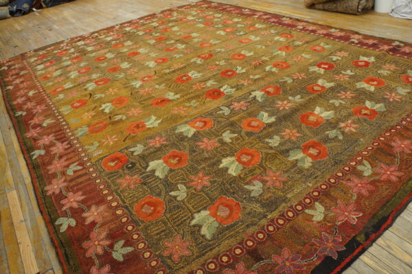Textured gold rug featuring large red roses and a detailed rust-red border, displayed on hardwood flooring.