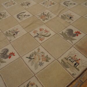 Cream and tan hooked rug displaying houses, roosters, and floral motifs in a diamond grid on wood floor.
