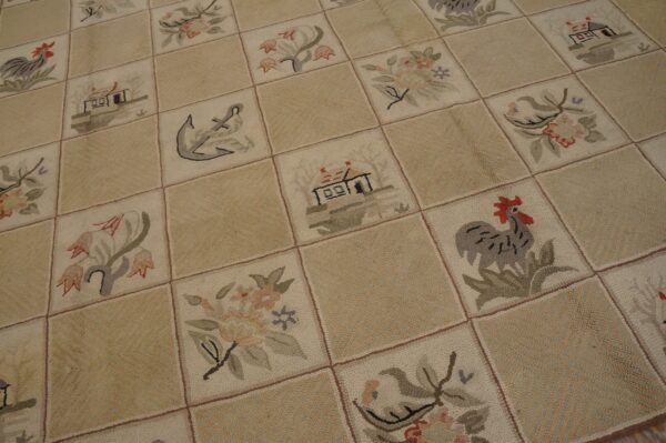 Cream and tan low-pile rug with checkerboard squares showing pictorial motifs like roosters and houses.